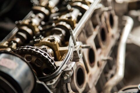 Close-up of an inline-six engine’s exposed cylinder head and timing chain