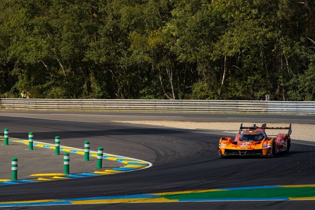 Orange prototype race car cornering over a trackday circuit apex