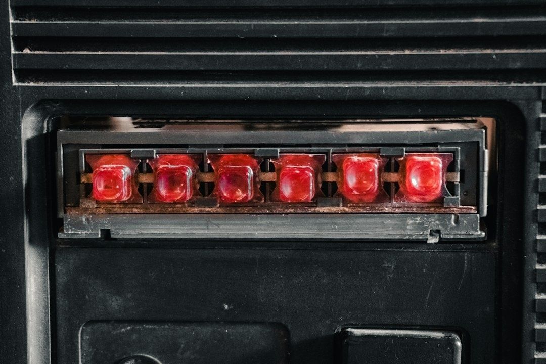 Close-up of six red automotive fuses mounted in a black fuse panel